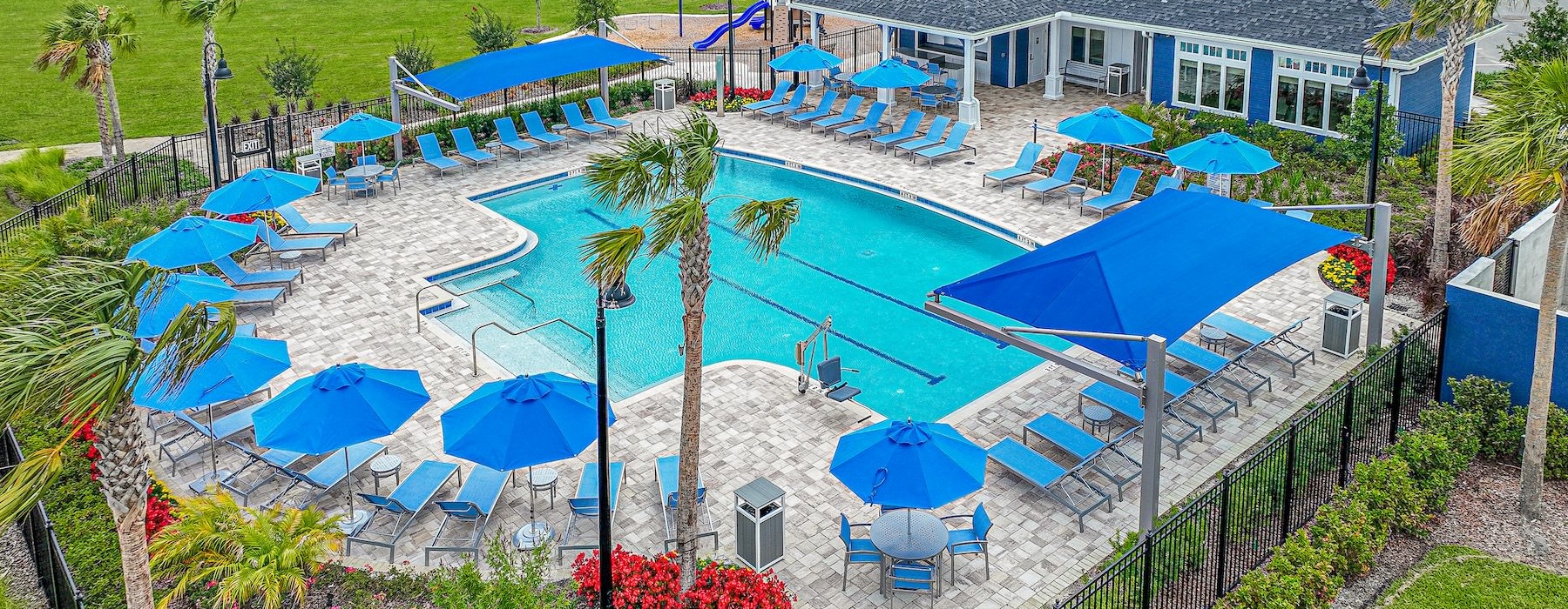 a pool with blue umbrellas and lounge chairs