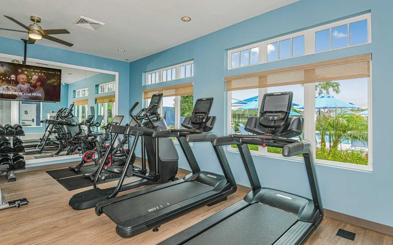 a room with exercise equipment and windows